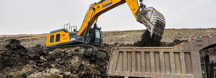 Excavator loading mined material into a truck